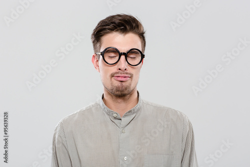 Young guy with closed eyes in black round glasses © Drobot Dean