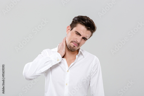Attractive man have a neck pain © Drobot Dean