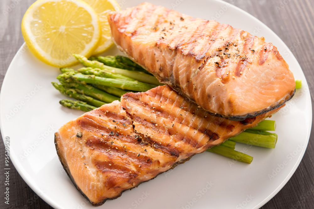 Grilled salmon and lemon, asparagus, on the wooden table