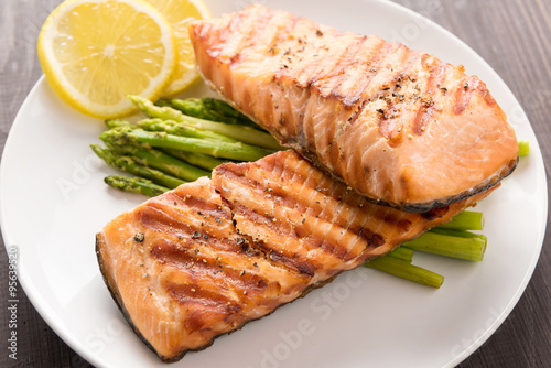 Grilled salmon and lemon, asparagus, on the wooden table