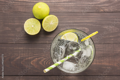 Fresh cocktail with soda, lime on a wooden background