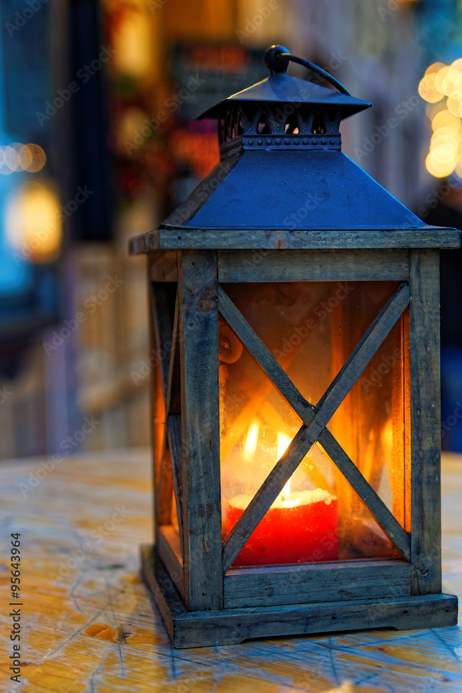 Burning lantern on wooden surface