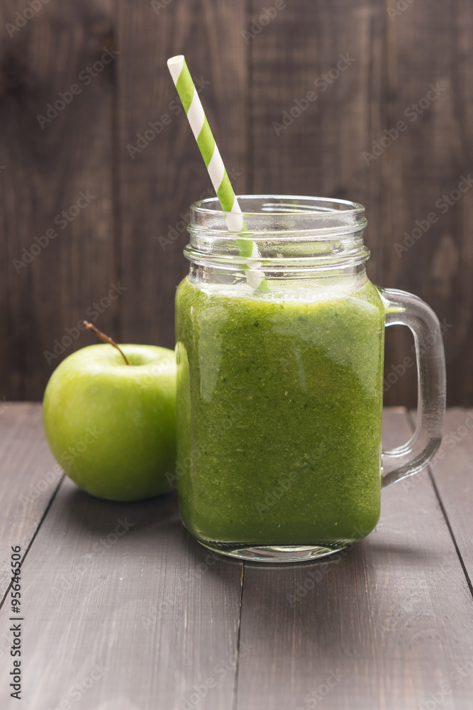 Healthy green vegetables and green fruit smoothie on rustic wood