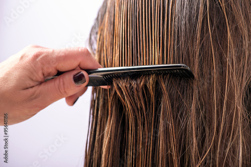 Photography Hairdresser combing a clients hair