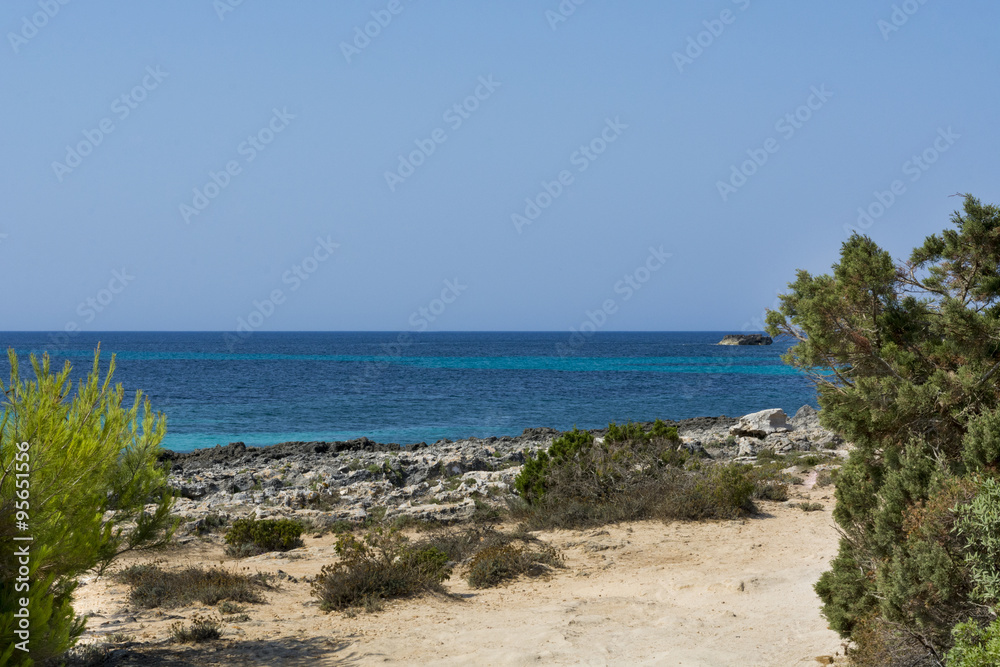 View of Cala Mitjana in Menorca during a summer day with blue sky a transparent water, Balearic Islands, Spain