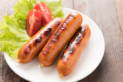 sausages laid on lettuce with tomato slices