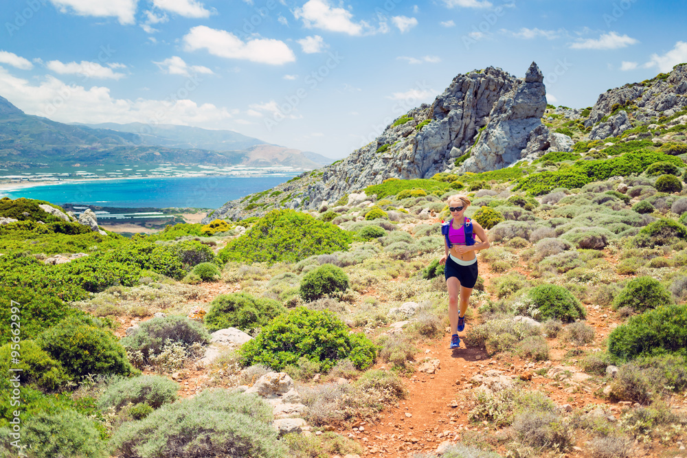 Happy woman trail running in beautiful inspirational landscape