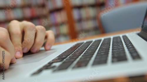 Young Handsome Man Sits and Moves Finger on the Trackpad