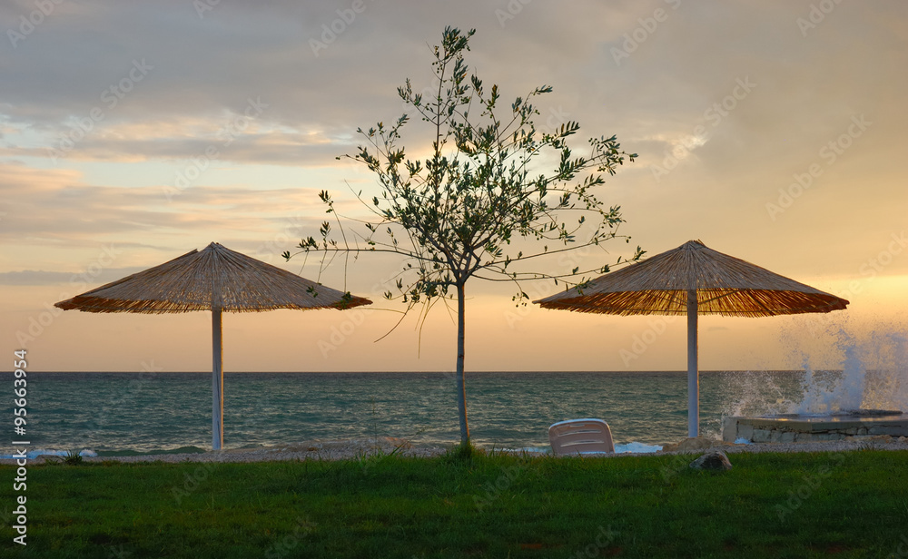 Relaxing sunset under straw beach umbrella