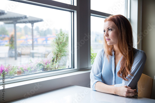 Cuadro en lienzo Woman with red hair looking out the window