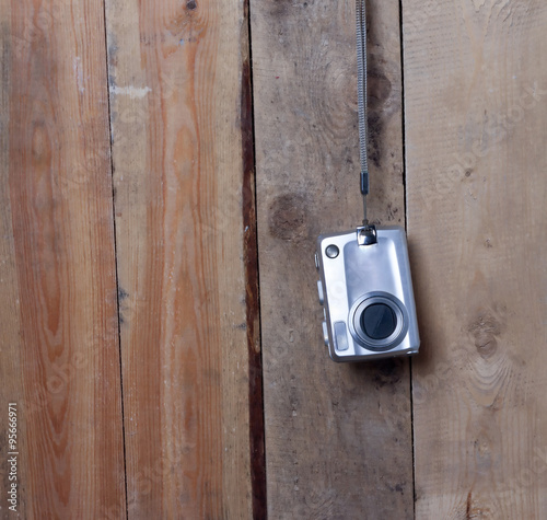 digital camera hanging on a wooden wall © correctim