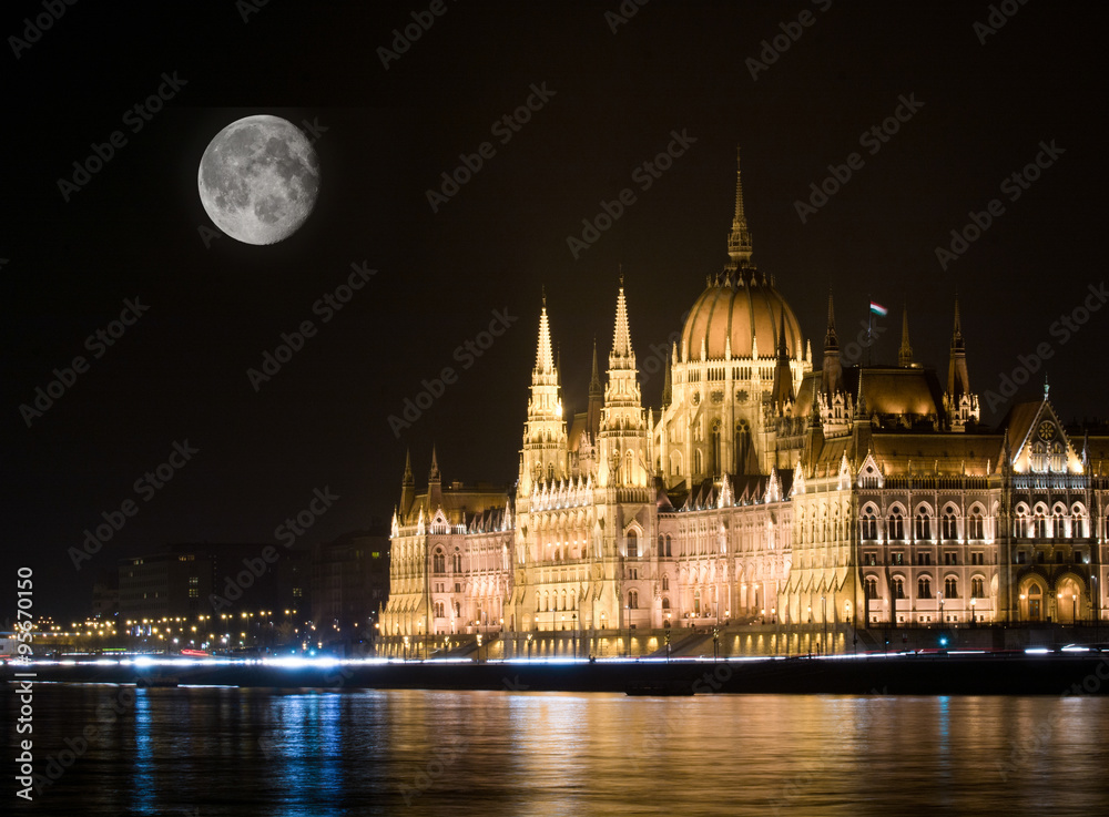 Obraz premium Night scene of the famous Parliament building and full moon on the sky in Budapest, Hungary