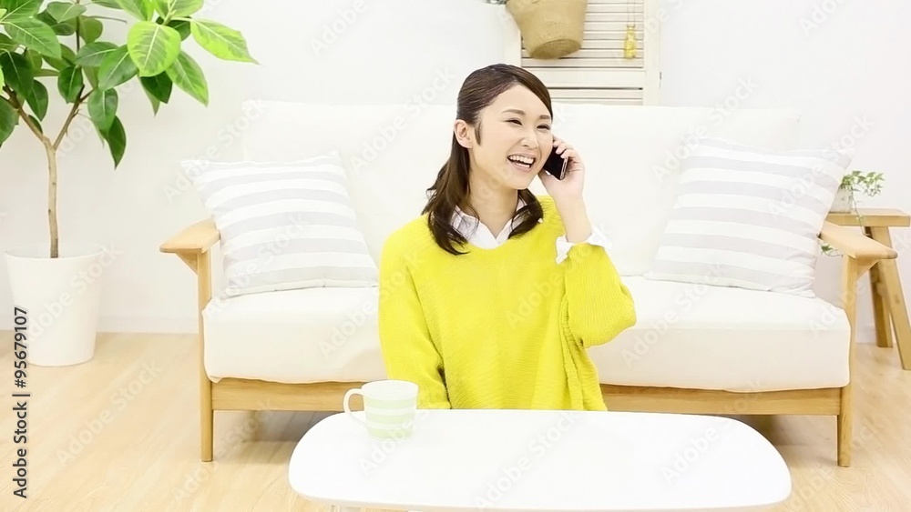 部屋でスマートフォンで話す女性　スライダー撮影