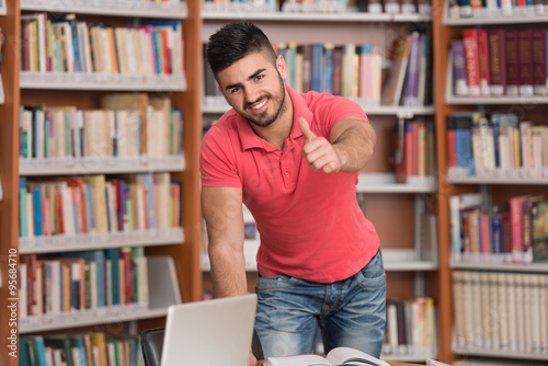 Young Man In A Library Showing Thumbs Up