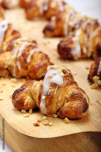 Croissant stuffed with walnuts on wooden background
