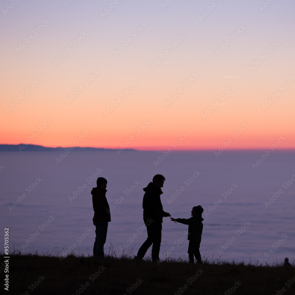 silhouetted family above inversion fog
