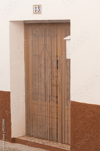 door with copper chains at the entrance to a Spanish house