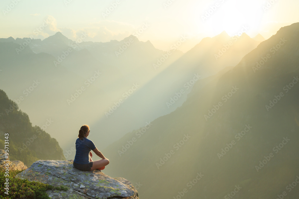 Woman relaxing en enjoying the summer sunset in the mountains. - obrazy, fototapety, plakaty 