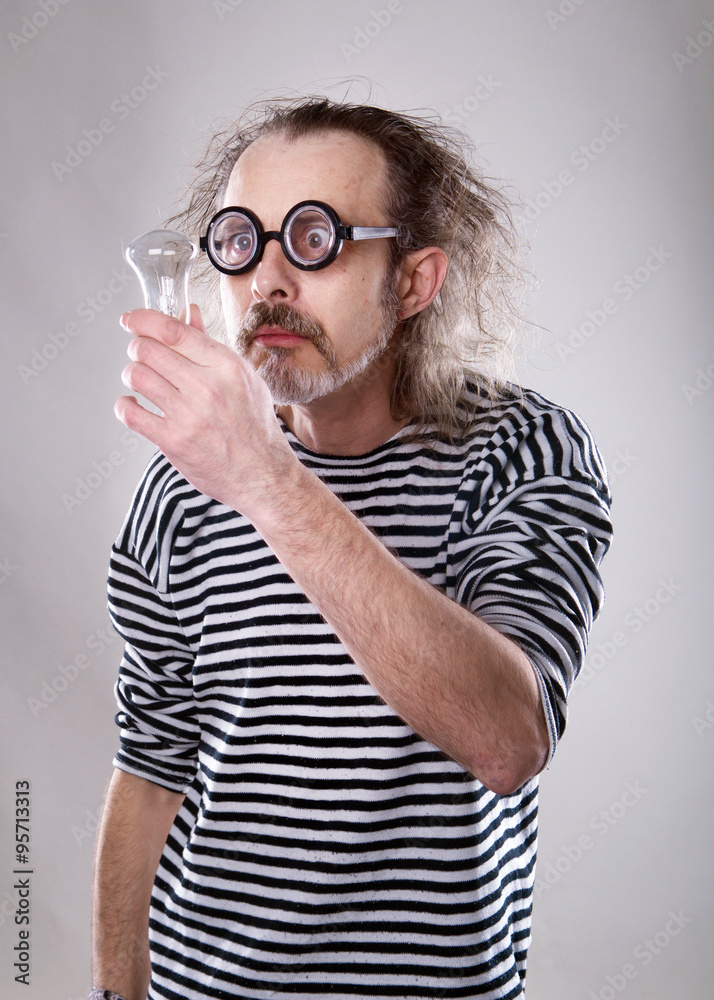 the aged man in a sailor looking at the lightbulb isolated on the white background 