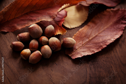 Hazelnuts with autumn leaves on the background of a wooden tabl