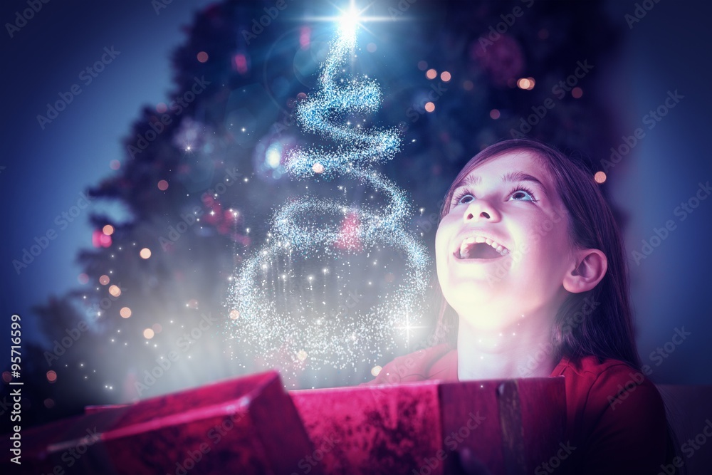 Composite image of little girl opening a magical christmas gift Composite image of little girl opening a magical christmas gift