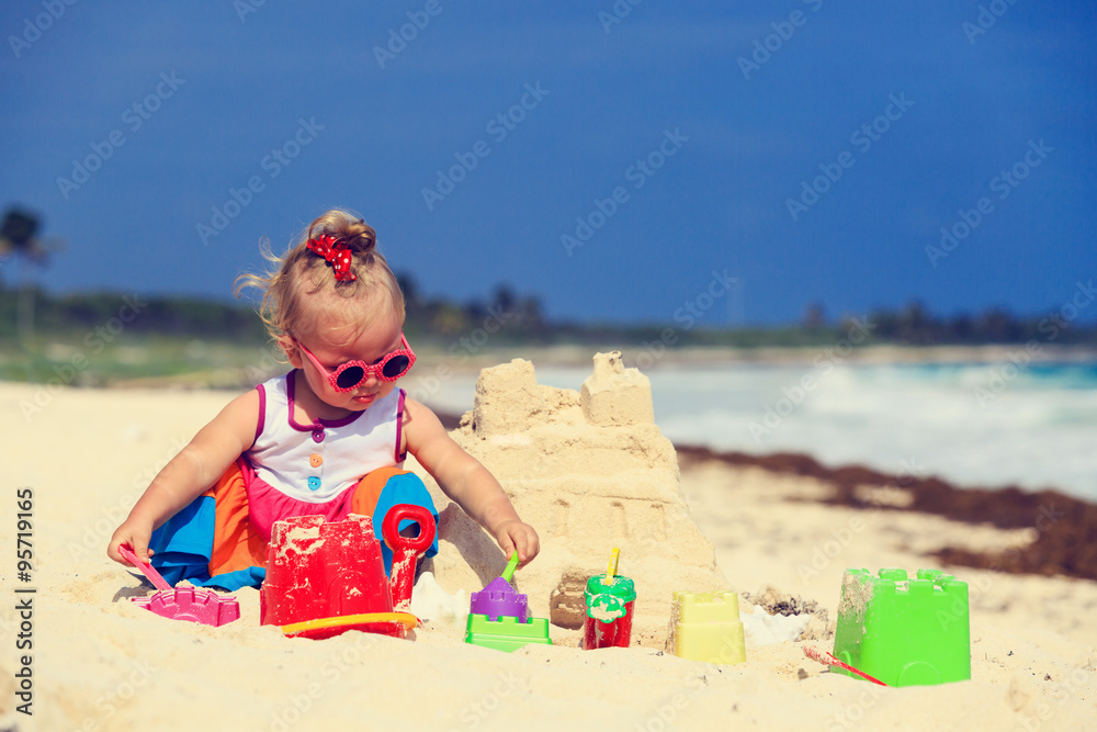 cute little girl building sandcastle on beach cute little girl building sandcastle on beach