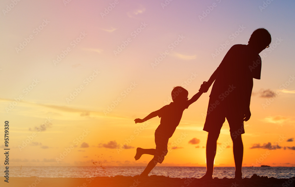 silhouettes of father and son having fun on sunset