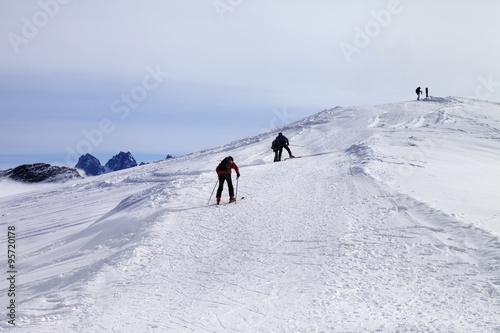 Skiers on ski slope at wind day
