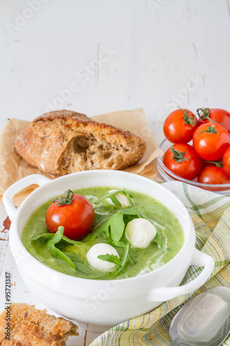 Arugula and tomatoes puree soup in white bowl photo