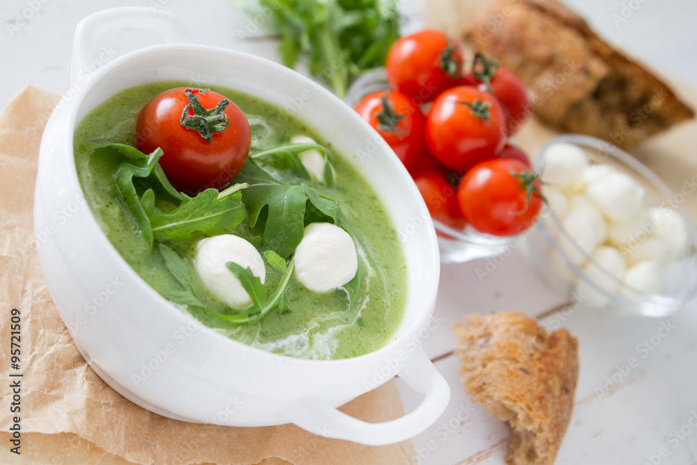 Arugula and tomatoes puree soup in white bowl Arugula and tomatoes puree soup in white bowl