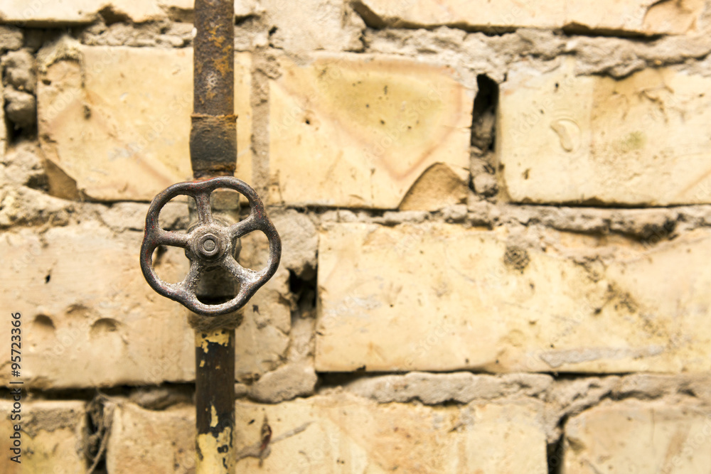 rusty pipeline valve on brick wall background rusty pipeline valve on brick wall background