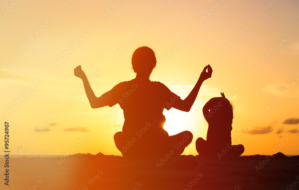 Fototapeta premium father and little daughter doing yoga at sunset