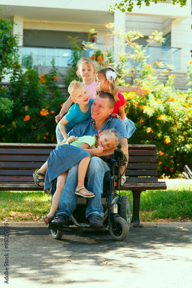 Disabled father with children having fun at the park