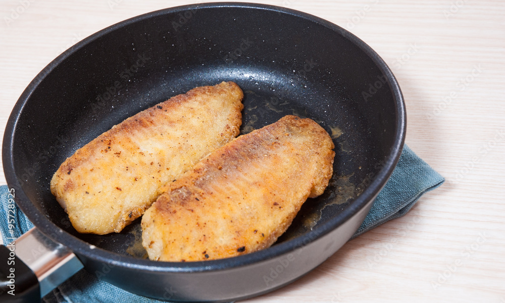 Fried fish fillet in a frying pan Fried fish fillet in a frying pan