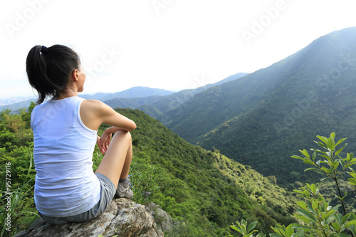 young woman enjoy the view at mountain peak 