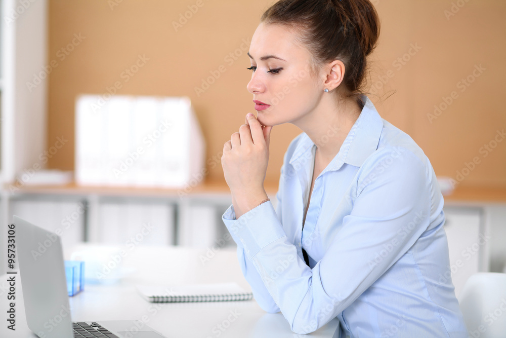 Young business woman working on laptop in office. Successful business concept. Young business woman working on laptop in office. Successful business concept.