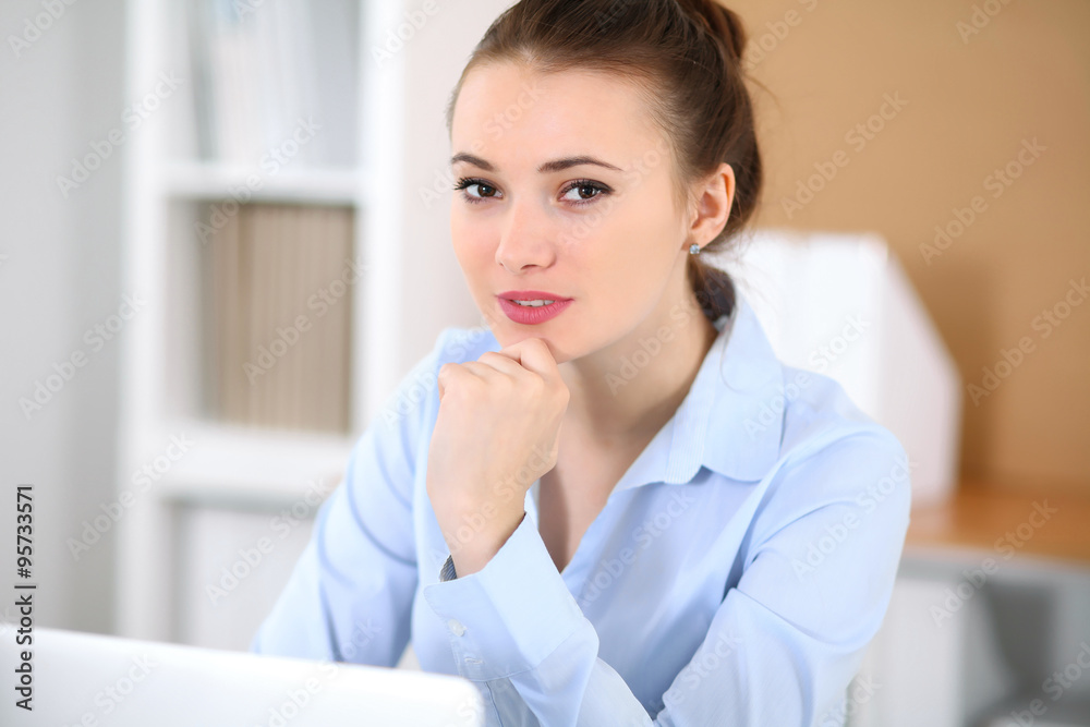 Young business woman working on laptop in office. Successful business concept. Young business woman working on laptop in office. Successful business concept.