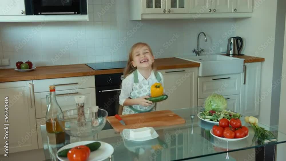 Crazy Chef playing with vegetables and looking at camera. Laughing girl