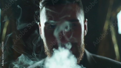 close-up of a bearded man in suit smoking electronic cigarette