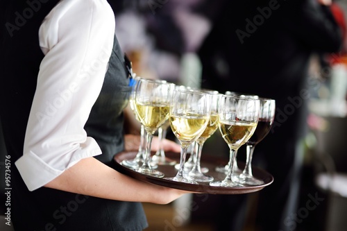 Schilderij op canvas Waitress with dish of champagne and wine glasses
