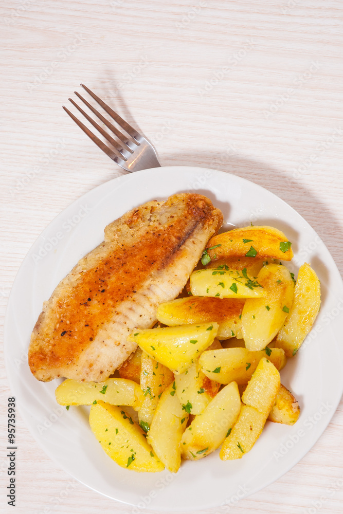 Fried fish fillet and potatoes in a plate Fried fish fillet and potatoes in a plate
