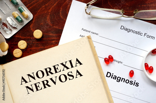 Foto anorexia nervosa  written on book with tablets. Medicine concept.