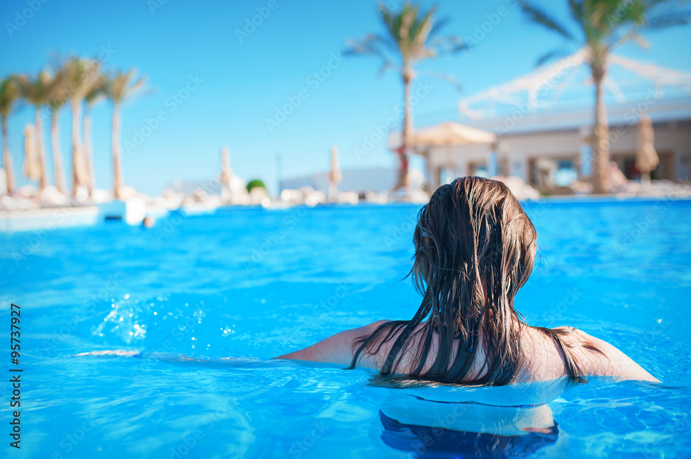 Young woman in the water in a blue swimming pool