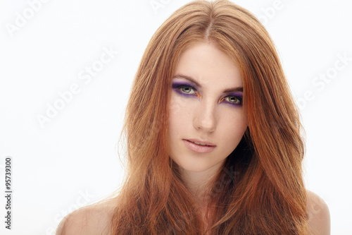 Closeup portrait of young cute smiling redhead lady with violet smokey eyes makeup isolated