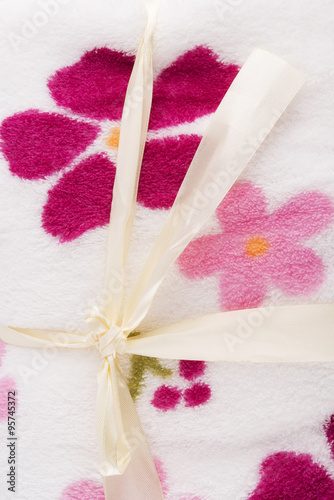 knot of ribbon on top blanket decorated with flowers photo