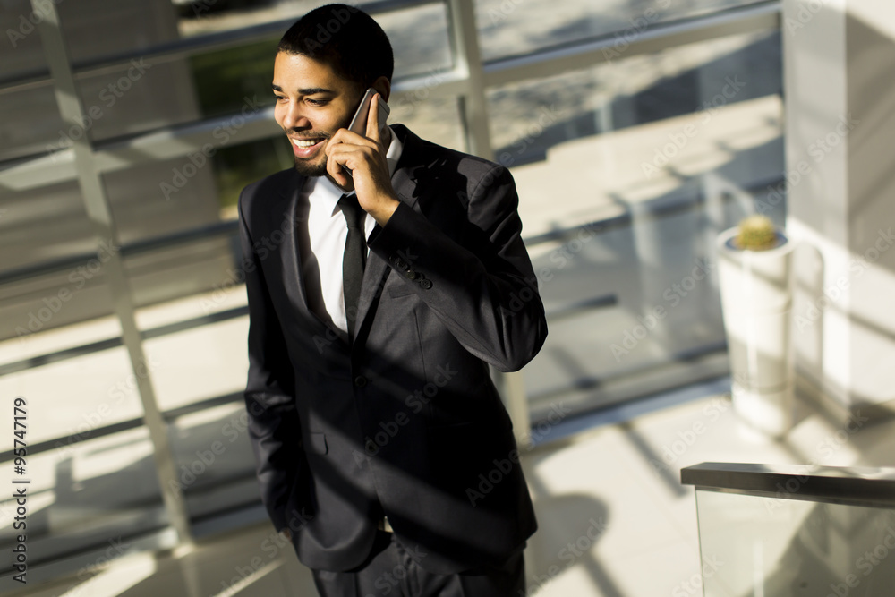 Handsome young black man with mobile phone in the office Handsome young black man with mobile phone in the office