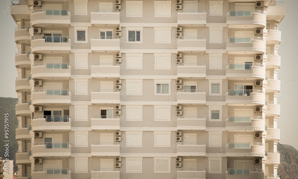 Facade of a block of flats. Sky and mountains behind. Toned Facade of a block of flats. Sky and mountains behind. Toned