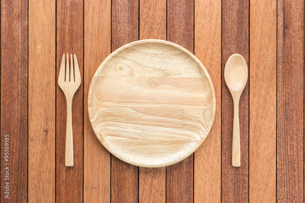Empty wooden dish, fork and spoon on wooden table Empty wooden dish, fork and spoon on wooden table