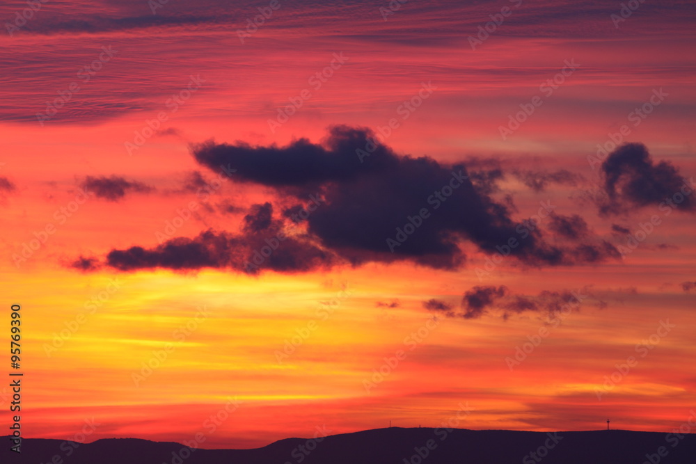 Wolke vor rotem Himmel bei Sonnenuntergang