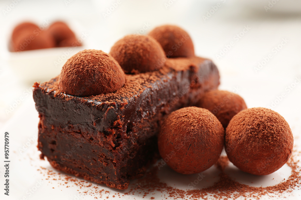 Slice of chocolate cake with a truffle on plate closeup Slice of chocolate cake with a truffle on plate closeup